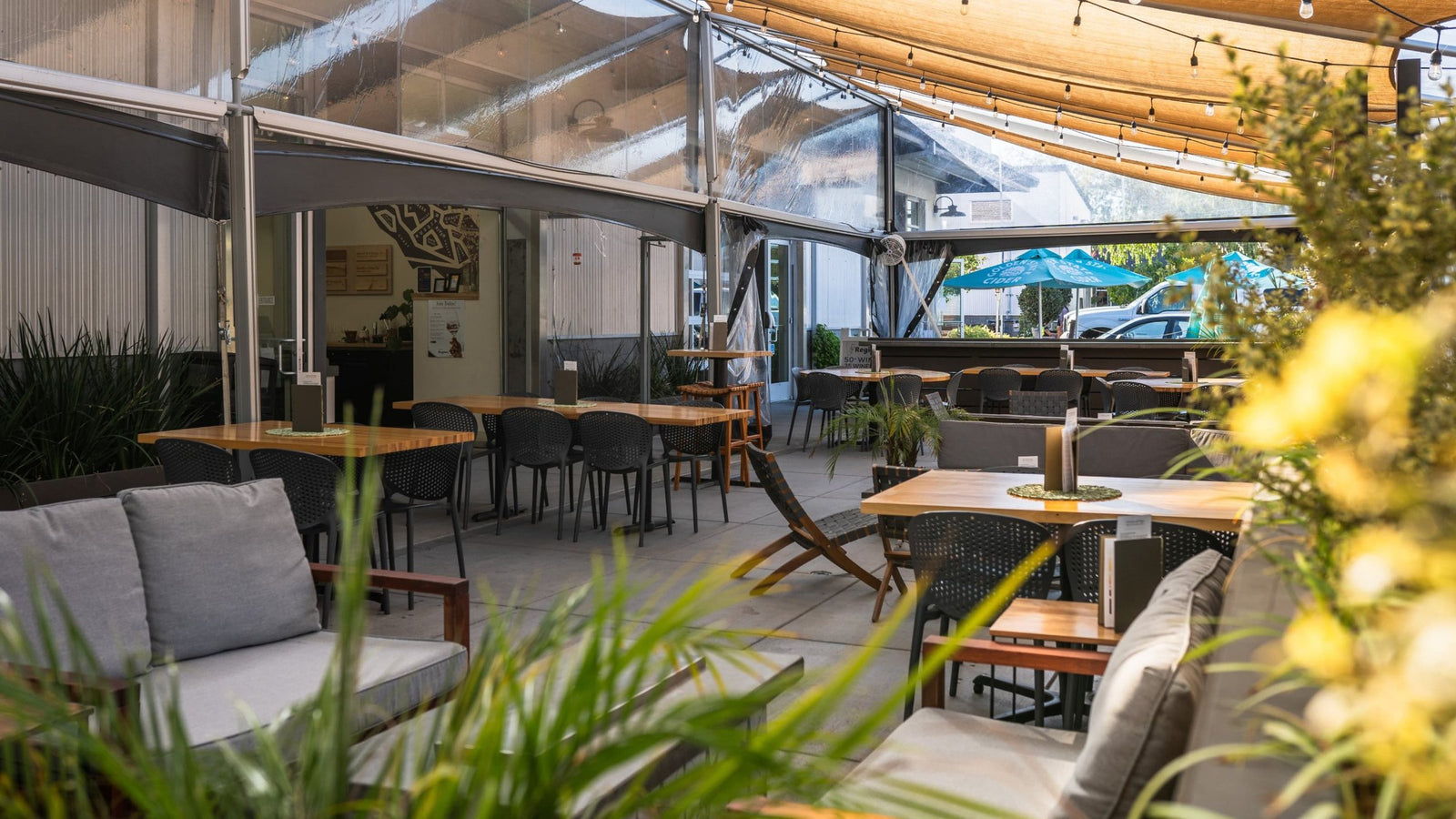 Covered patio at Region.Sonoma with string lights, lounge seating and long tables